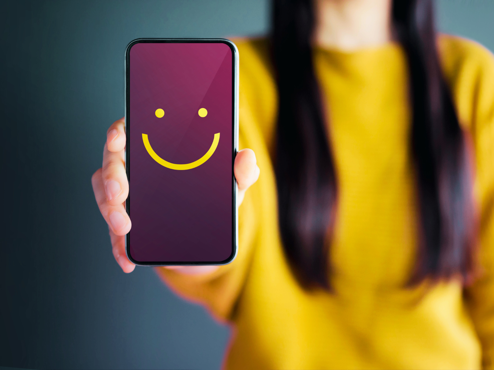 women showing a smiley in cellphone